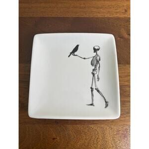 Ceramic stoneware plate-decorative with a skelton holding a bird